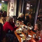 Group of people eating and drinking at a restaurant.