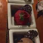 Three desserts in white bowls with strawberries.