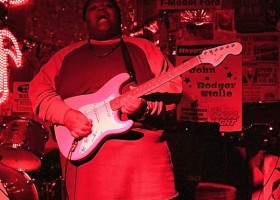 Man playing electric guitar on stage.