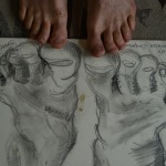 Feet on top of a charcoal drawing.