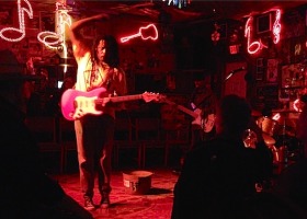 A man plays electric guitar on stage.