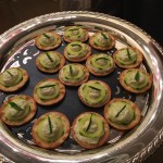 Silver platter of cucumber and cream cheese bites.