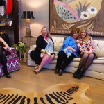 Four women pose in a living room.