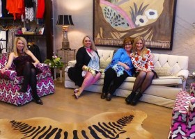 Four women pose in a living room.