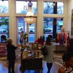 A boutique interior with women shopping and a chandelier.