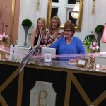 Three women cutting ribbon for grand opening.