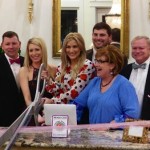 Group of people smiling at a ribbon cutting ceremony.