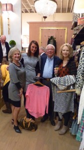 Group of people shopping for clothes in store.