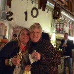 Two women smiling in a shop with candles.