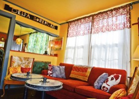 Bohemian living room with red couch.