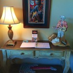 Wooden table with guitar and sign.