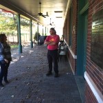 Two people standing in front of a brick building.