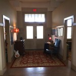 Hallway with doorway, rug, and framed art.