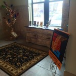 A black and tan rug with a wooden dresser.