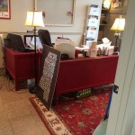 Red desk with a lamp and a large book.