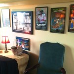 Framed artwork and a blue armchair in a room.