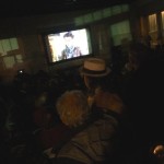 People watch a movie on a screen.