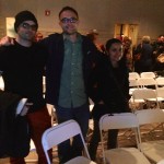 Three friends smiling at a party with chairs.