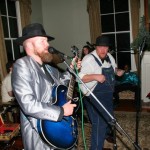 Two men playing music with a guitar.