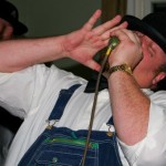 Man in overalls singing into microphone.