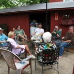 Group of people sitting around a table outside.