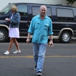 Man in blue shirt standing by a van.