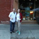 Two people standing in front of a brick building.