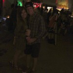 Couple in a dimly lit room holding drinks.