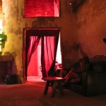 Woman sitting on couch in dimly lit room.