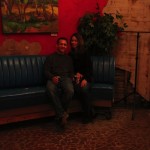 Couple sitting on a blue couch in a room.