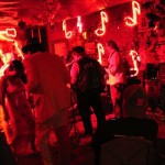 Group of people dancing in a red lit room.