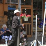 Man playing drums in front of a store.