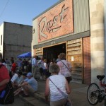 Group of people outside a building with "Rust" sign.