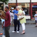 A group of people, some playing music, outdoors.