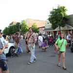 People gathered outside a store on a sunny day.