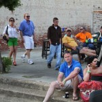 Group of people sitting and standing outdoors.