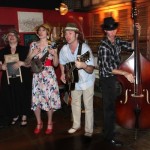 Four people playing music in a bar.