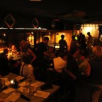 People socializing at a dimly lit bar.