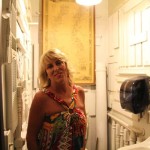 Woman in a floral dress stands in a bathroom.