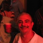 Smiling man holding a red cup.