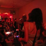 Group of people at a party with red lighting.