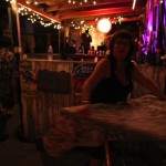 Woman with long hair sits at a bar