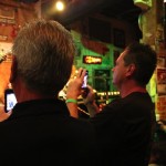 Man takes photo of band playing live music.