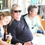 Three friends smiling and enjoying drinks.