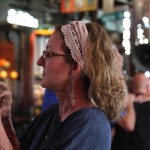 Woman with curly hair wearing a head scarf.