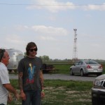 Two men standing by a silver trailer.