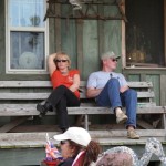 Two people sitting on a porch swing.