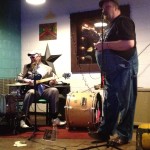 Two men playing music in a bar.