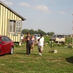 Three people stand in front of a house.