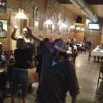 Group of people in a restaurant with brick walls.